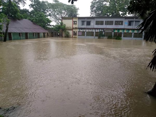 A primary school in Feni's flood-hit area is submerged under knee-deep water, disrupting classes and daily activities for students and staff. Photo: Voice7 News